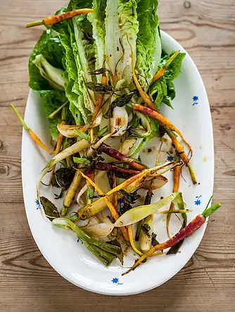 Bagte nye gulerødder og løg med mynte, løvstikke og sprød romainesalat