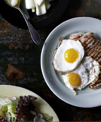 Grillet skinkeschnitzel med spejlæg, nye porrer og salat med radiser 