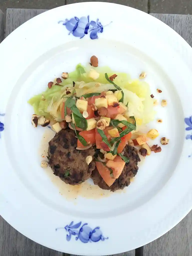 Krydderbøffer med spidskål, ramsløg, æbler og hasselnødder