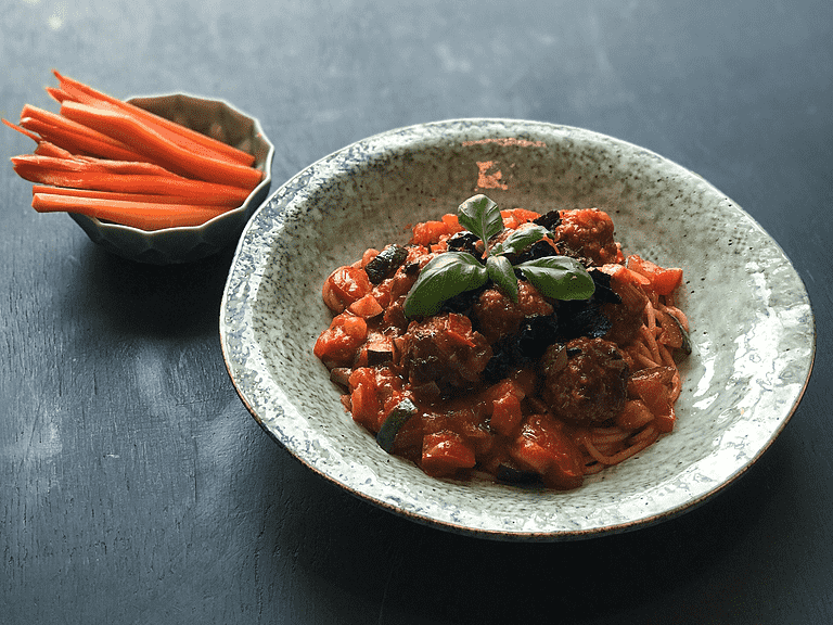 Kødboller i tomat-grøntsagssauce med frisk pasta, basilikum og oliven