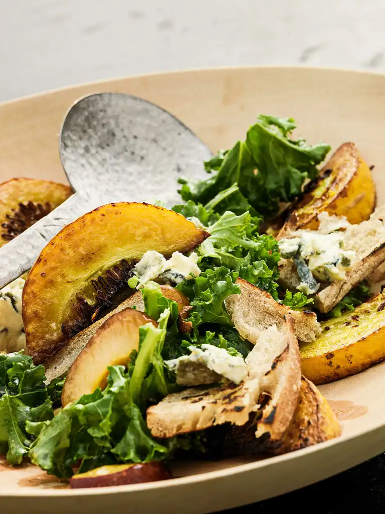 Salat af stegt græskar med blommer, grønkål, grillet brød og blåskimmelost