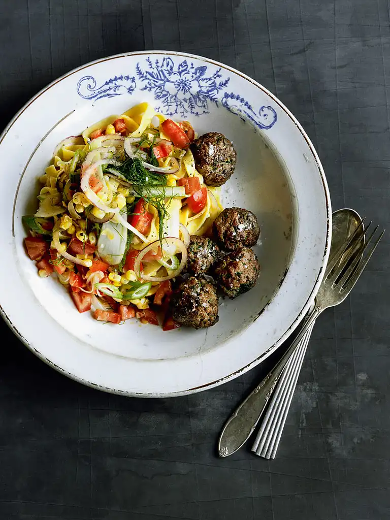 Stegte kødboller med krydderurter og lun pasta, majs og tomater 